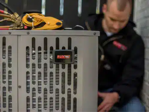 Employee providing AC maintenance to unit