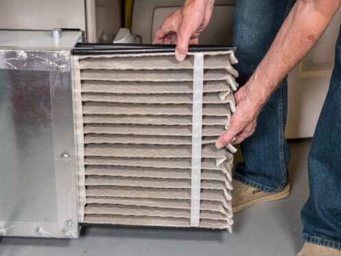 Employee installing furnace filter