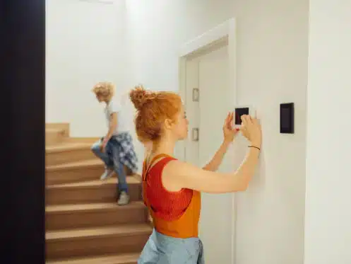 Women adjusting thermostat