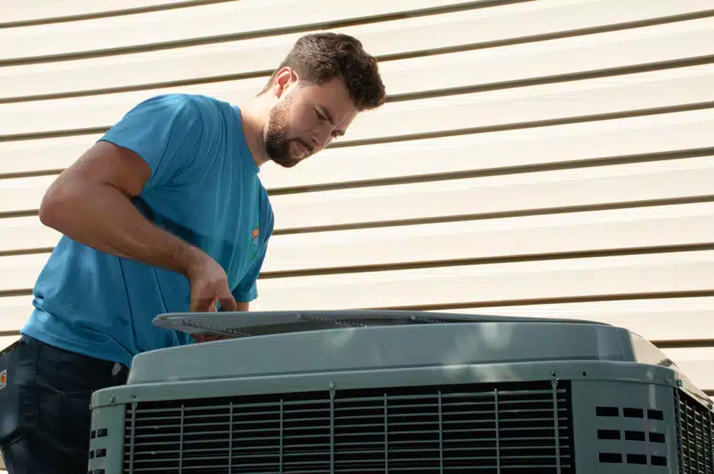 Employee Brandon, from Absolute Heating & Air, conducting AC maintenance for a home in Morgantown, WV