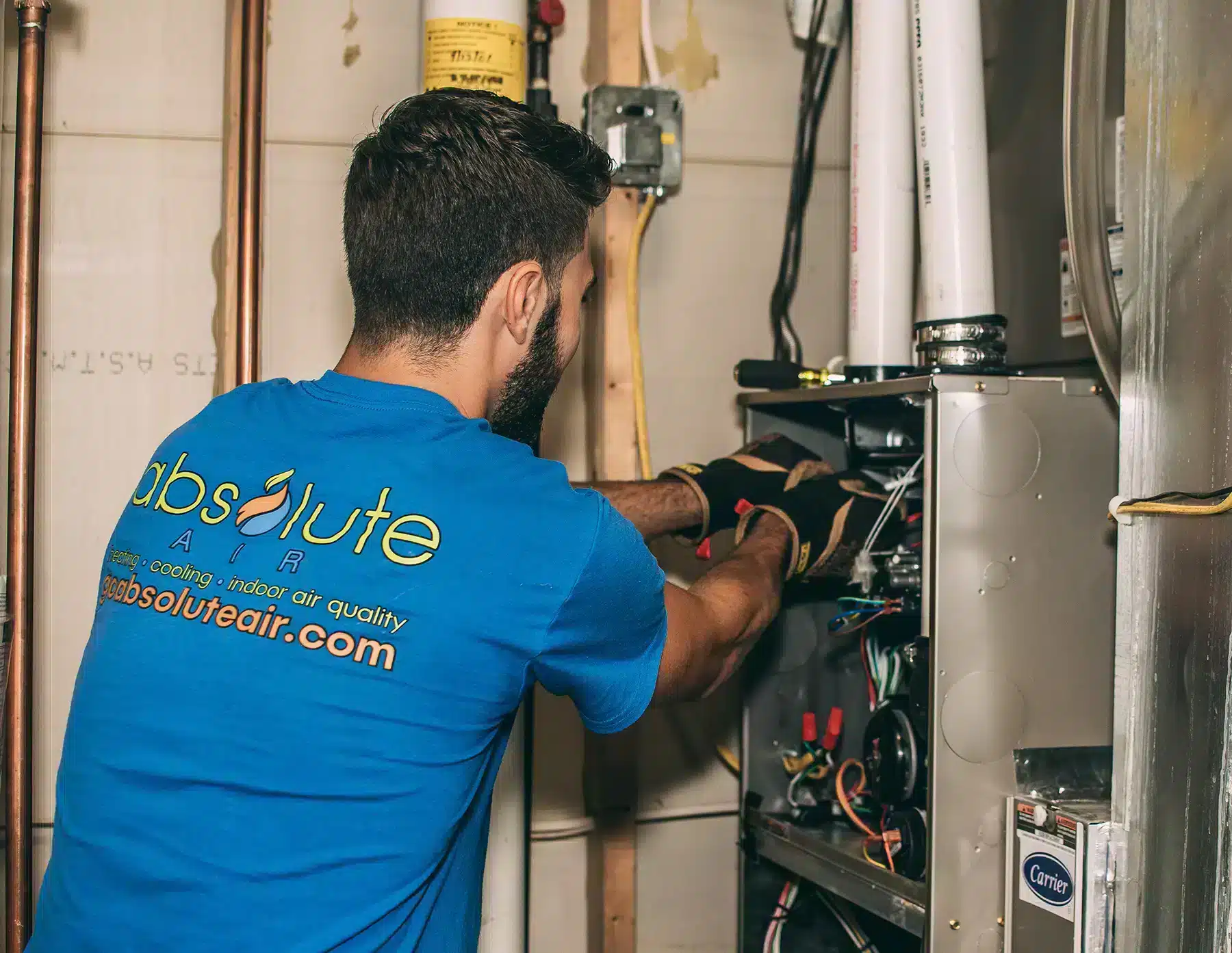 Absolute Heating & Air employee conducting furnace repairs in Morgantown, WV