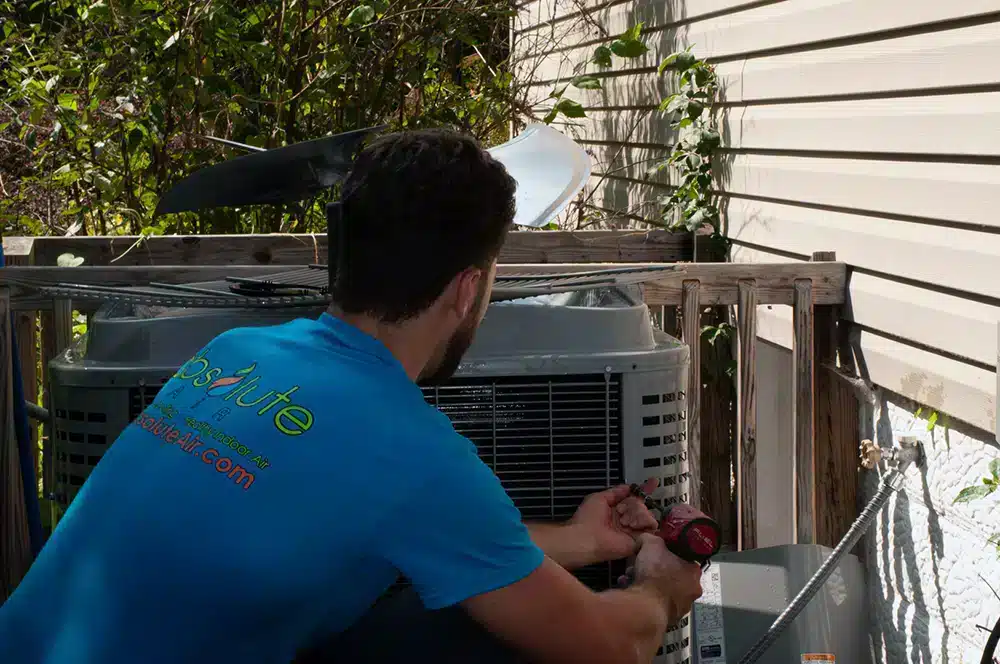 Absolute Heating & Air technician, Tristan, conducting AC maintenance for home in Morgantown, WV
