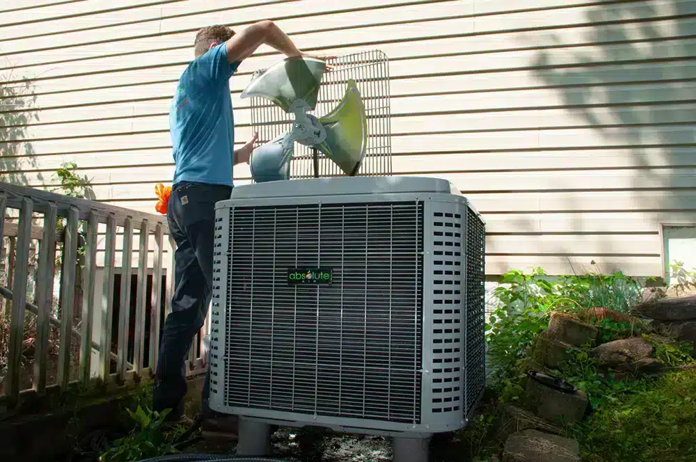 Absolute Heating & Air technician providing maintenance outside of a home in Morgantown, WV
