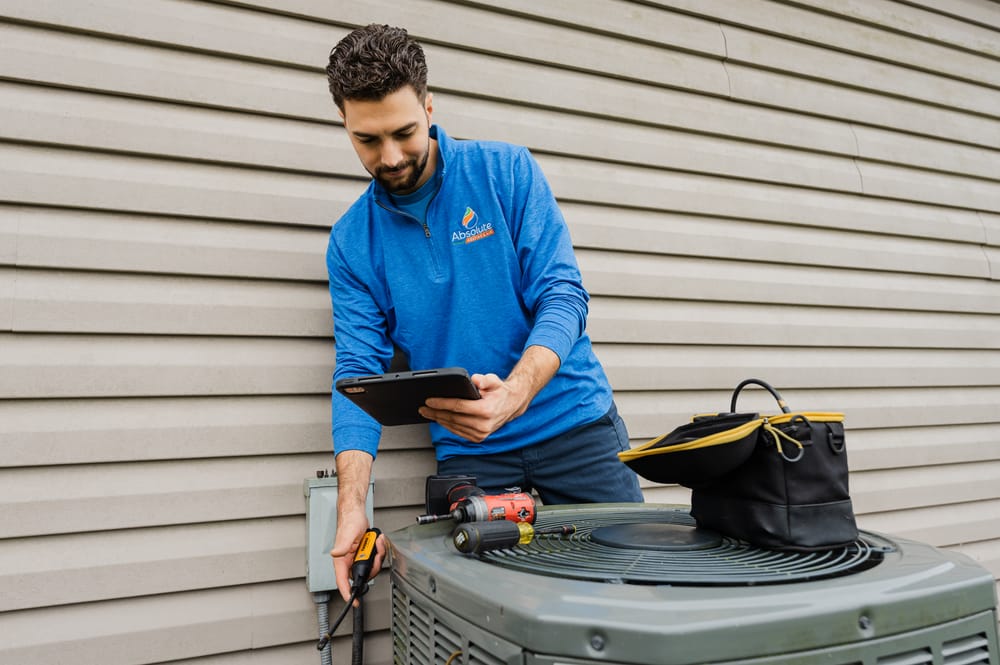 HVAC technician holding iPad during ac installation.