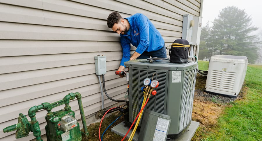Technician conducting ac repair to outdoor ac unit.