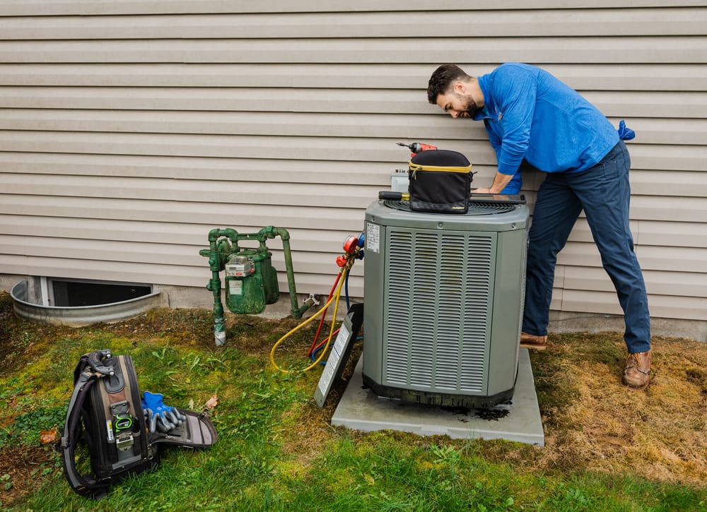 HVAC technician working on an air conditioning system outside.