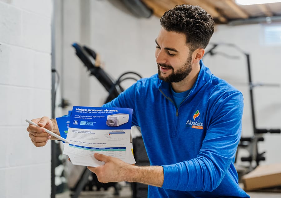Absolute technician holding an air purifier pamphlet.
