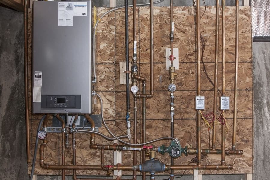 A boiler installed on exposed wall.