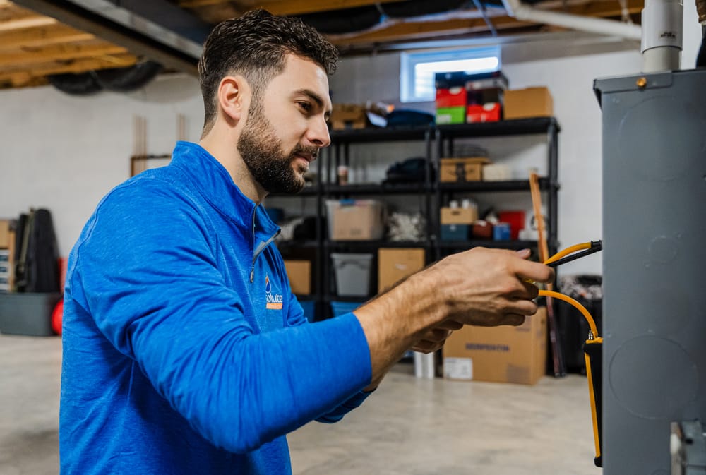 Technician working on boiler in basement.