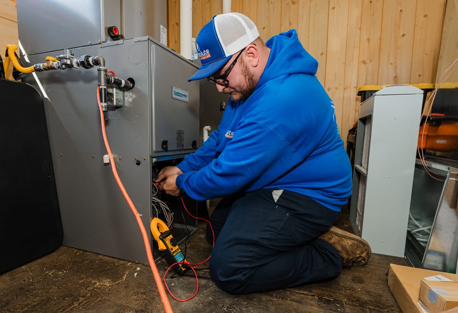 Techniain repairing a furnace.
