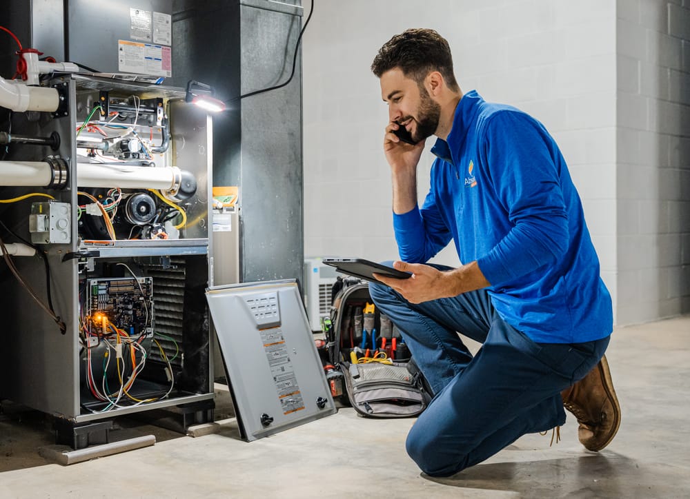 Tech kneeling in front of heater during heater maintenance.