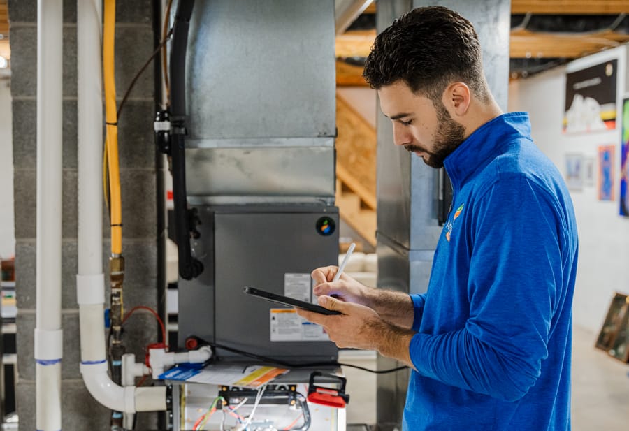 HVAC technician conducting maintenance on heating system.