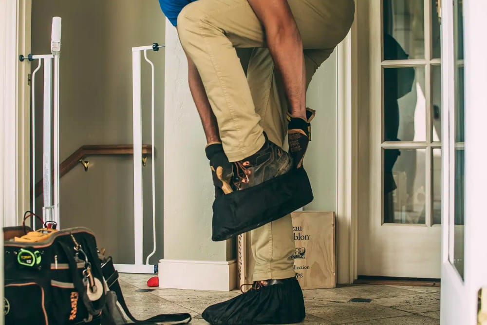 Absolute technician putting on shoe masks to protect client floors.
