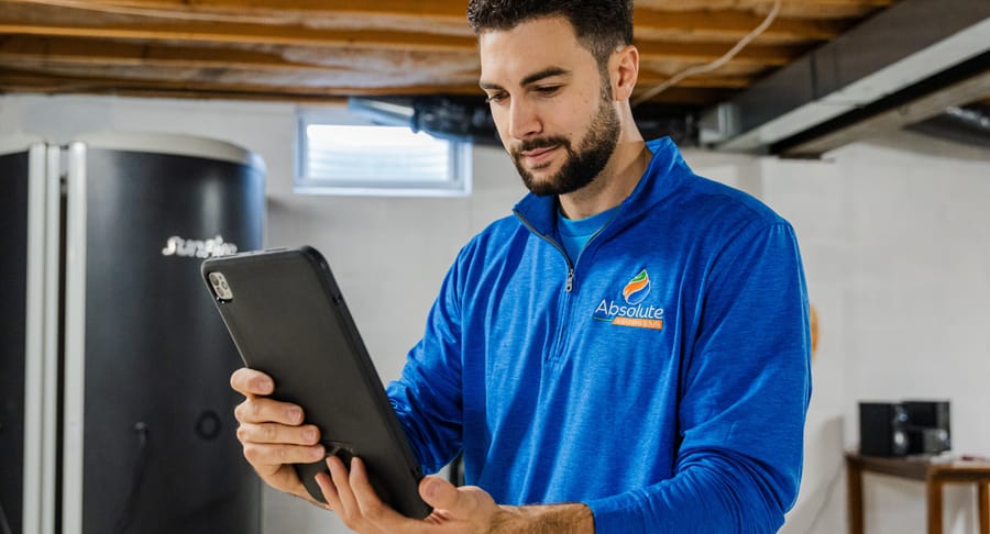 Technician looking at an iPad during tankless water heater inspection.