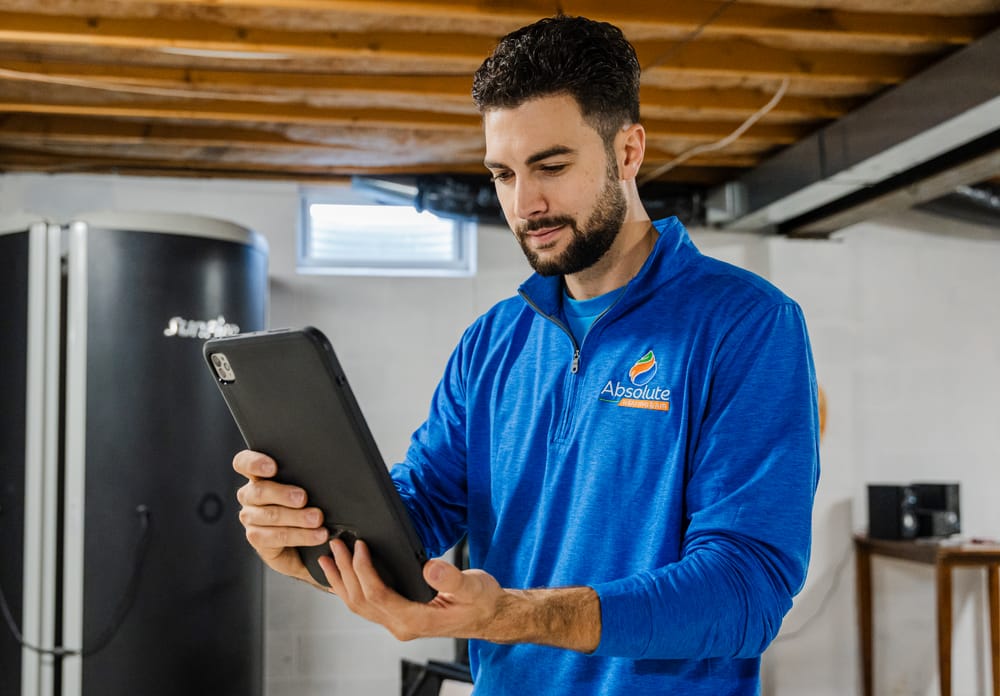 Absolute technician at water heater appointment holding iPad.