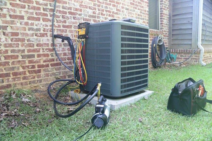 Outdoor air conditioning system with toolbox on the grass in front of it